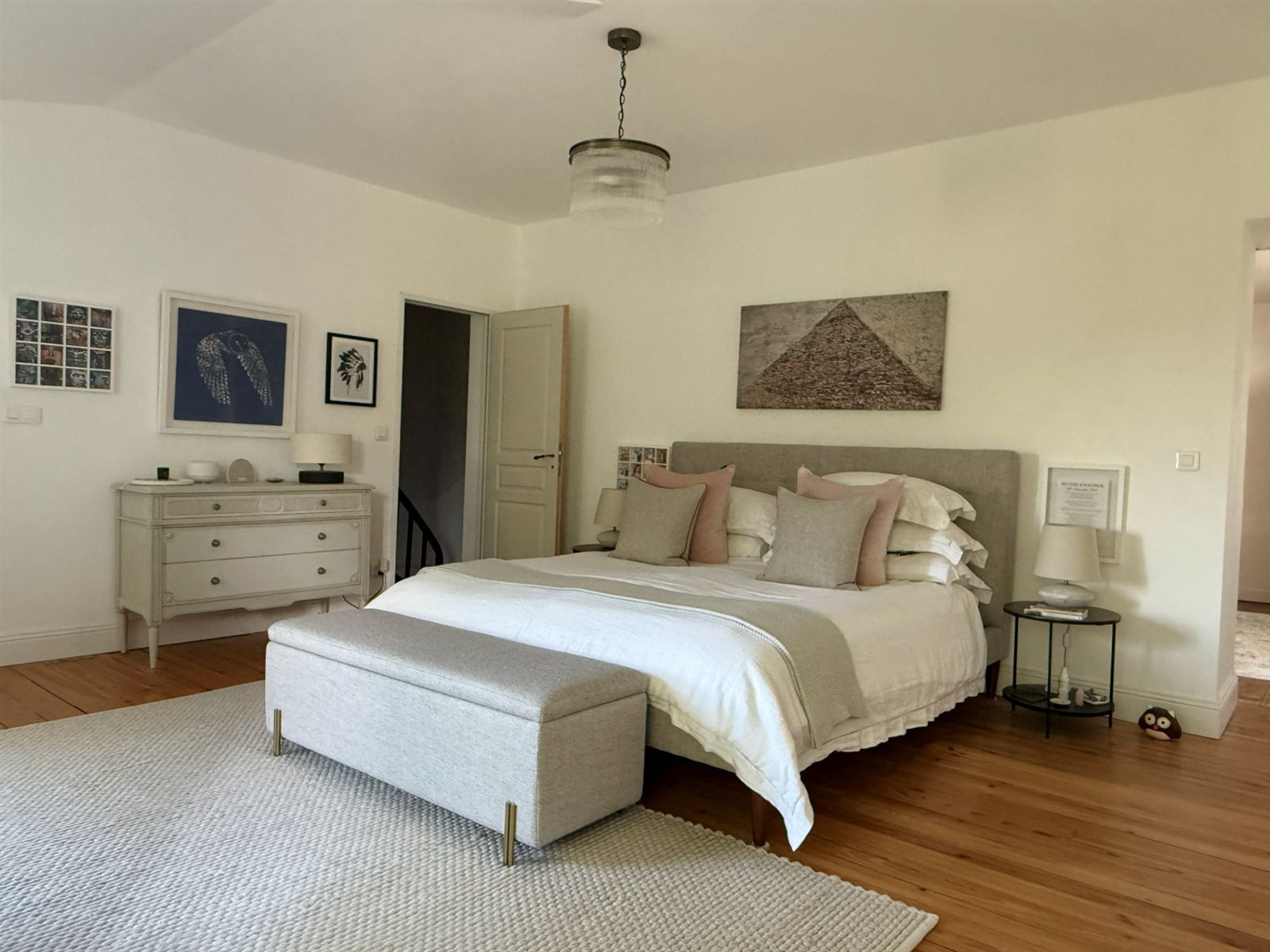 Master bedroom with an upholstered bed and dresser