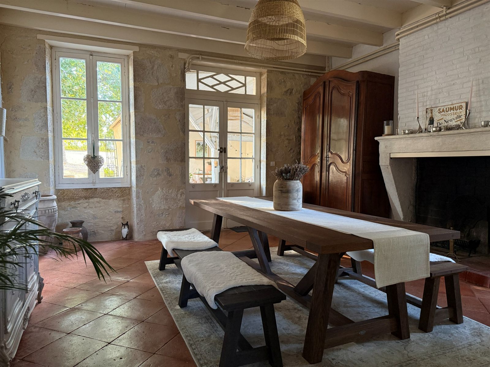 Dining room with a timber table, exposed stone and fireplace