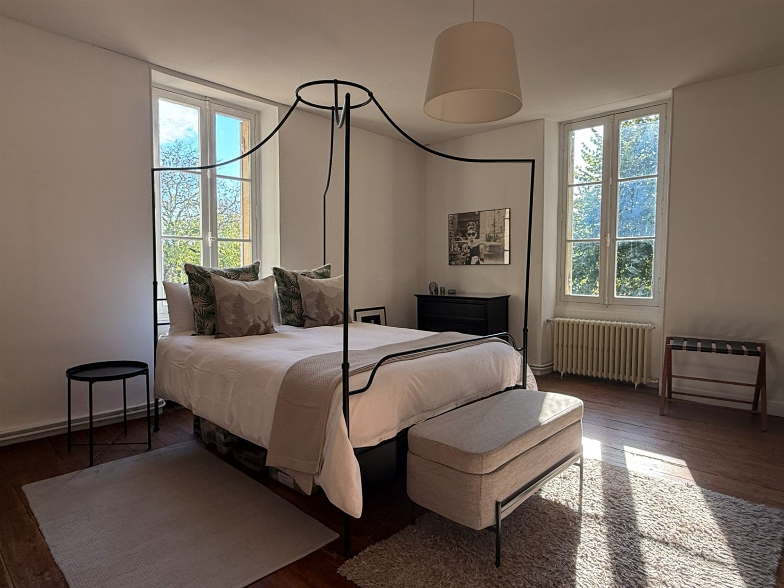 Black and white bedroom with a four-poster bed and tall windows